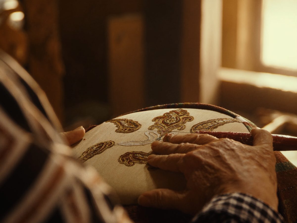 Kashmiri artisan hand-embroidering a pashmina shawl